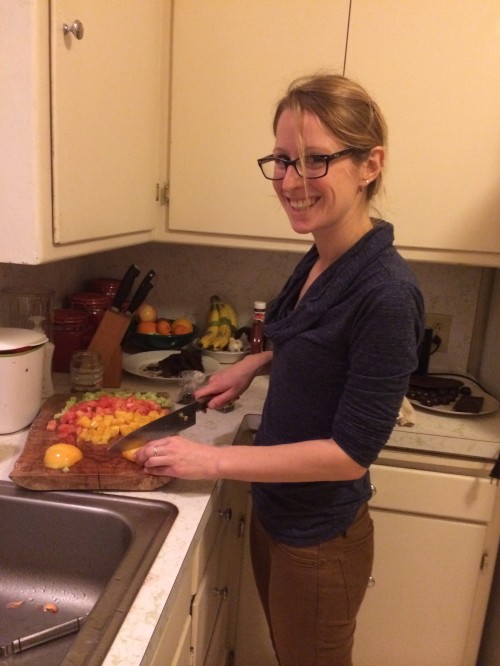 Rachel chopping tomatoes for cucumber tomato salad to go with the Sabih