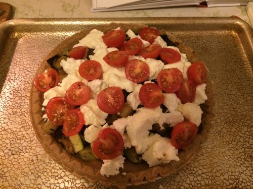 Very full tart with roasted vegetables, cheese, and cherry tomatoes