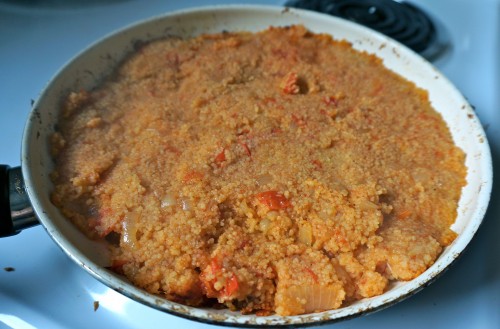 Couscous with tomatoes and onion in pan