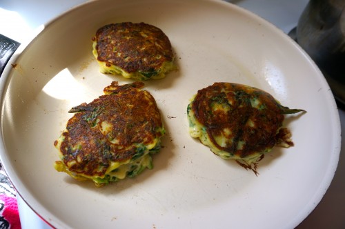 Green pancakes browning in the pan