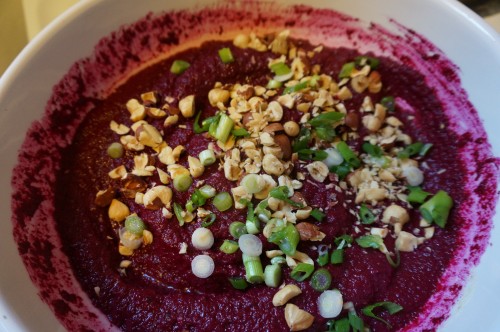 Beet dip with roasted hazelnuts and green onion garnish