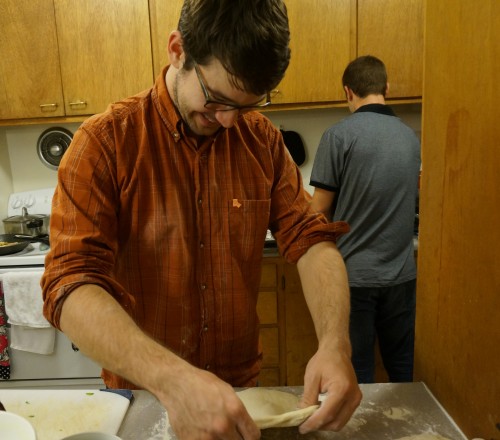 Max happily rolling out the pizza dough