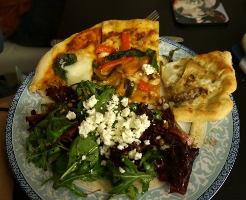 Plate loaded down with salad and all 3 pizzas
